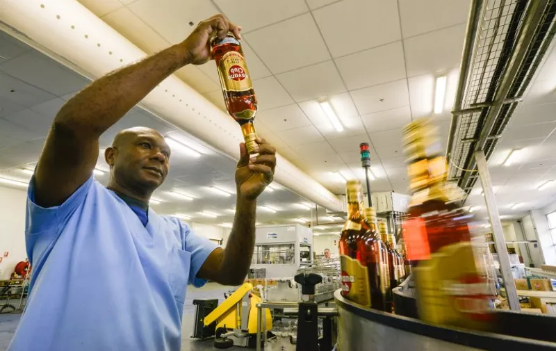 A worker checks bottles at the factory of the Cuban rum Havana Club, in San Jose de las Lajas, in the Cuban province of Mayabeque, on November 22, 2013 -- day which marks the 20th anniversary of the alliance between the rum company Havana Club International and France's Pernod Ricard group.   AFP PHOTO/ADALBERTO ROQUE / AFP PHOTO / ADALBERTO ROQUE