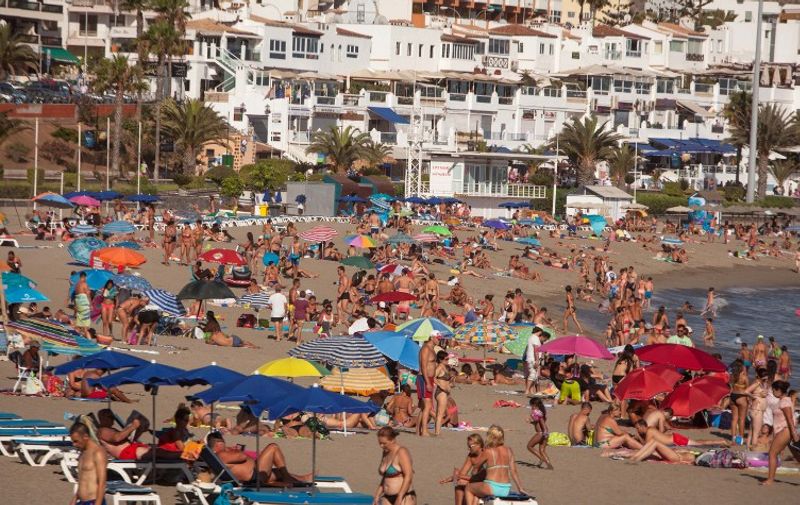 Thousands of tourists sunbathe on the beach of Las Vistas in Los Cristianos on the southern coast of the Canary island of Tenerife, on July 25, 2015. Spain saw some 29.2 million foreign tourists visit in the first half of 2016, a new record for this key sector of its economy. More than a quarter (25.5%) of foreign visitors choose to stay in Catalonia  with the Canary Islands and the Balearic Islands and Andalusia in tow as favored destinations. AFP PHOTO / DESIREE MARTIN