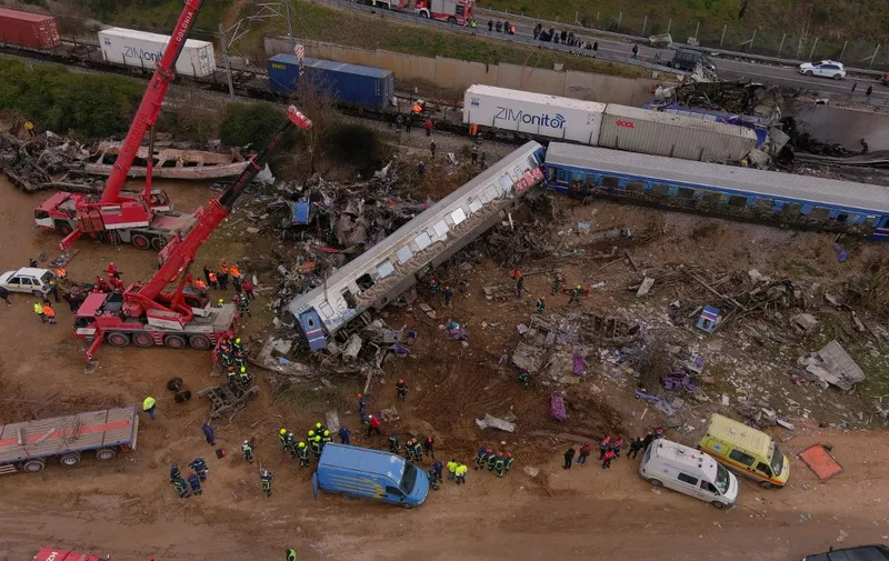 This aerial drone photograph taken on March 1, 2023, shows emergency crews examining the wreckage after a train accident in the Tempi Valley near Larissa, Greece. - At least 32 people were killed and another 85 injured after a collision between two trains caused a derailment near the Greek city of Larissa late at night on February 28, 2023, authorities said. A fire services spokesman confirmed that three carriages skipped the tracks just before midnight after the trains -- one for freight and the other carrying 350 passengers - collided about halfway along the route between Athens and Thessaloniki. (Photo by STRINGER / AFP)
