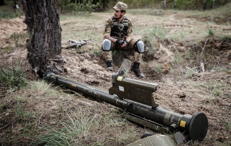 A Ukrainian soldier sits next to an anti-aircraft missile while taking some rest near Lyman, eastern Ukraine, on April 28, 2022, amid Russian invasion of Ukraine. (Photo by Yasuyoshi CHIBA / AFP)