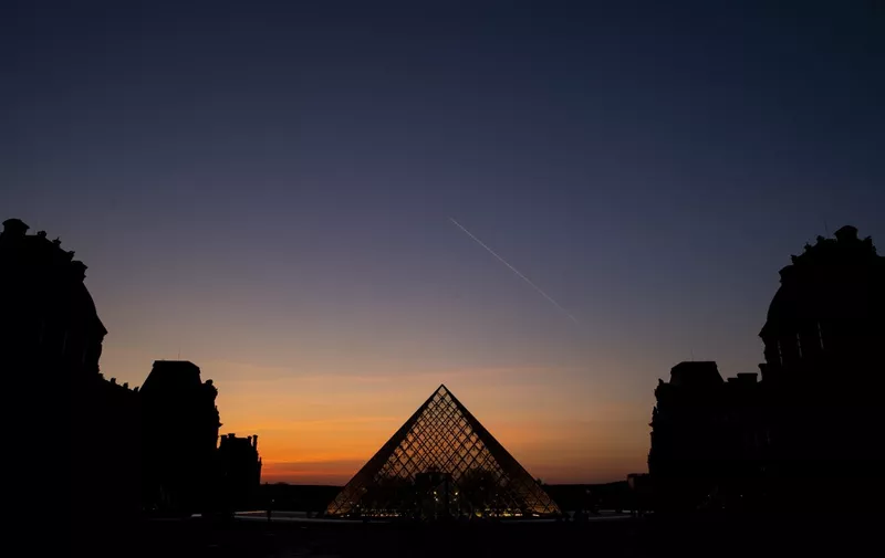 (FILES) In this file photo taken on March 21, 2019 the sun sets behind the Louvre Pyramid, designed by Chinese-American architect I.M. Pei, in Paris. - I.M. Pei, the preeminent US architect who forged a distinct brand of modern building design with his sharp lines and stark structures, has died, The New York Times said on May 16, 2019. He was 102 years old. (Photo by KENZO TRIBOUILLARD / AFP) / RESTRICTED TO EDITORIAL USE - MANDATORY MENTION OF THE ARTIST UPON PUBLICATION - TO ILLUSTRATE THE EVENT AS SPECIFIED IN THE CAPTION
