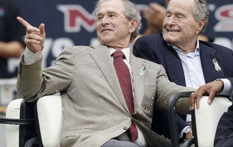 HOUSTON, TX - NOVEMBER 17: Former Presidents George W. Bush (L) and George H.W. Bush attend a game between the Oakland Raiders and Houston Texans at Reliant Stadium on November 17, 2013 in Houston, Texas.   Bob Levey/Getty Images/AFP