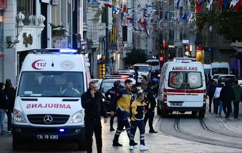 Ambulances ride as Turkish policemen try to secure the area after a strong explosion of unknown origin shook the busy shopping street of  Istiklal in Istanbul, on November 13, 2022. - Istanbul governor Ali Yerlikaya tweeted that four people died and 38 were wounded according to preliminary information. (Photo by Yasin AKGUL / AFP)