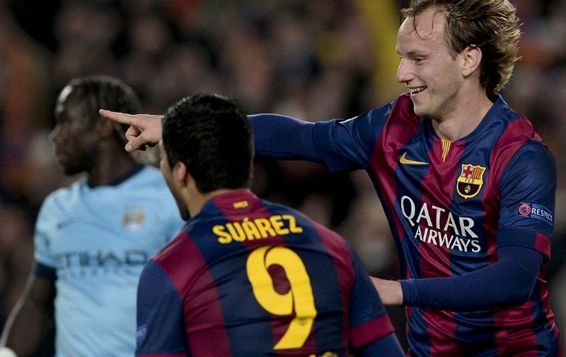 Barcelona's Croatian midfielder Ivan Rakitic (R) celebrates his goal during the UEFA Champions League round of 16 football match FC Barcelona vs Manchester City at the Camp Nou stadium in Barcelona on March 18, 2015. AFP PHOTO/ 