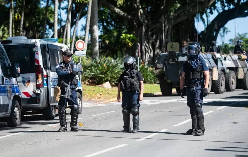 Police in riot gear are seen outside a police station in Noumea, France's Pacific territory of New Caledonia, on May 18, 2024. Hundreds of French security personnel tried to restore order in the Pacific island territory of New Caledonia on May 18, after a fifth night of riots, looting and unrest. (Photo by Delphine Mayeur / AFP)