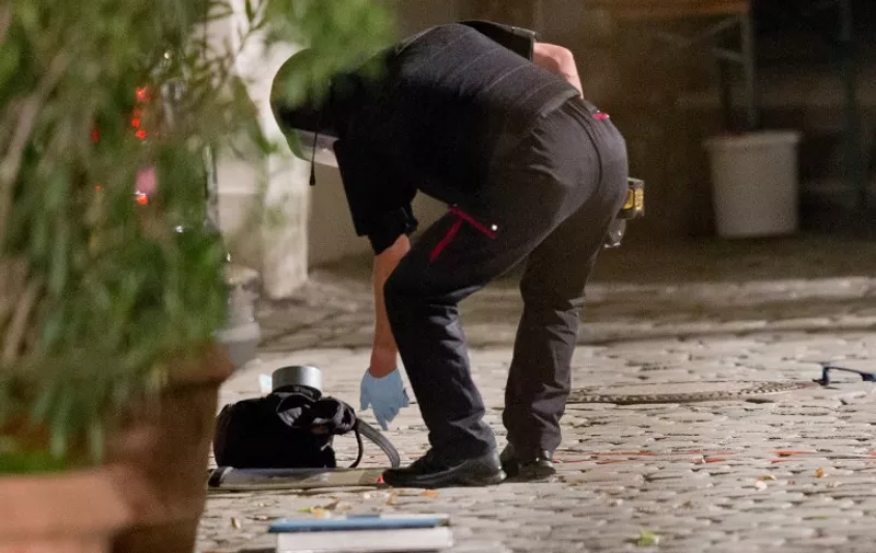A polic officer in protective gear inspects a back pack used to carry an explosive device at the scene of a suicide attack in the southern German city of Ansbach on 25 June, 2016 
A Syrian migrant set off an explosion at a bar in southern Germany that killed himself and wounded a dozen others late Sunday, authorities said, the third attack to hit Bavaria in a week.
The 27-year-old, who had spent a stint in a psychiatric facility, had intended to target a music festival in the city of Ansbach but was turned away because he did not have a ticket.
 / AFP PHOTO / dpa AND DPA / Daniel Karmann / Germany OUT