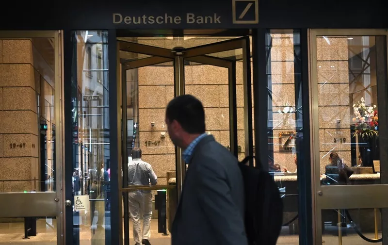 A man is seen outside the US headquarters of Deutsche Bank on July 8, 2019 in New York City. - From Asia to the United States, disconsolate staff at Deutsche Bank dealt Monday with news of massive layoffs with some already heading to the exits to drown their sorrows.The German giant's share price fell to a low of 6.66 euros ($7.47) before closing down 5.4 percent at 6.79 euros, following Sunday's announcement of 18,000 job losses by 2022 as the company transitions out of high-risk investment banking. (Photo by Angela Weiss / AFP)