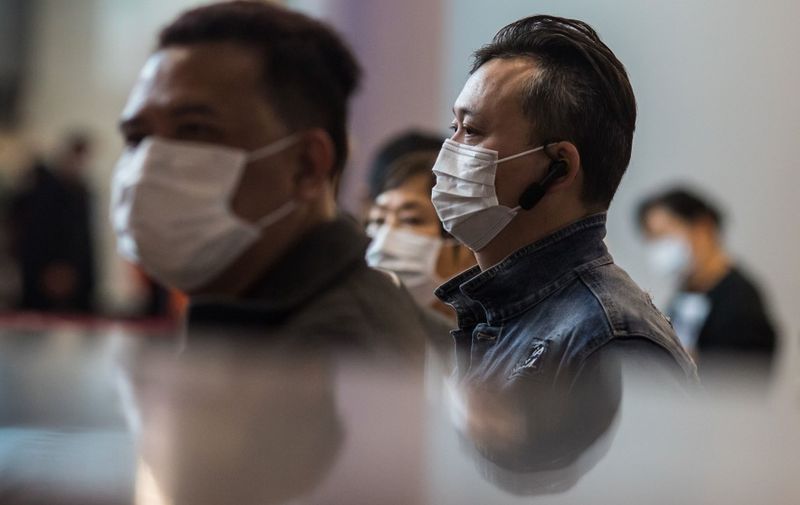 Passengers wearing masks queue at ticketing booths at a high-speed train station connecting Hong Kong to mainland China on January 26, 2020, as a preventative measure following a coronavirus outbreak which began in the Chinese city of Wuhan. - Hong Kong on January 25 declared a mystery virus outbreak as an "emergency" -- the city's highest warning tier -- as authorities ramped up measures aimed at reducing the risk of further infections spreading. (Photo by DALE DE LA REY / AFP)