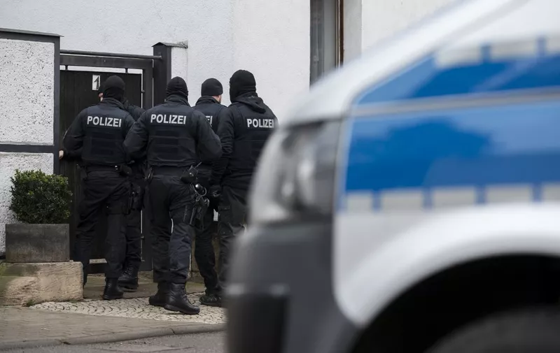 Policemen stand on January 23, 2019 in front of a house in the Vieselbach district of Erfurt, eastern Germany, where a raid took place in connection with the ban of the neo-Nazi group Combat 18. - The German government announced it had banned the neo-Nazi group Combat 18, an organisation founded in Britain that was implicated in the murder of a German municipal official in the year 2019. (Photo by Jens-Ulrich Koch / dpa / AFP) / Germany OUT