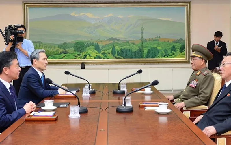 This handout photo released by the South Korean Unification Ministry shows the South Korean president's national security adviser, Kim Kwan-Jin (2nd L), and Unification Minister Hong Yong-Pyo (L) talking with the North Korean military's top political officer Hwang Pyong-So (2nd R) and North Korean top official in charge of South Korea affairs, Kim Yang-Gon (R), during their meeting at the truce village of Panmunjom in the Demilitarized Zone (DMZ) dividing the two Koreas on August 22, 2015. North and South Korea sat down to urgent top-level talks on August 22, seeking some way out of an escalating crisis that has pushed both their militaries to the brink of an armed conflict.   AFP PHOTO / South Korean Unification Ministry             
---- EDITORS NOTE ---- RESTRICTED TO EDITORIAL USE   MANDATORY CREDIT "AFP PHOTO / The South Korean Unification Ministry"   NO MARKETING NO ADVERTISING CAMPAIGNS  -  DISTRIBUTED AS A SERVICE TO CLIENTS