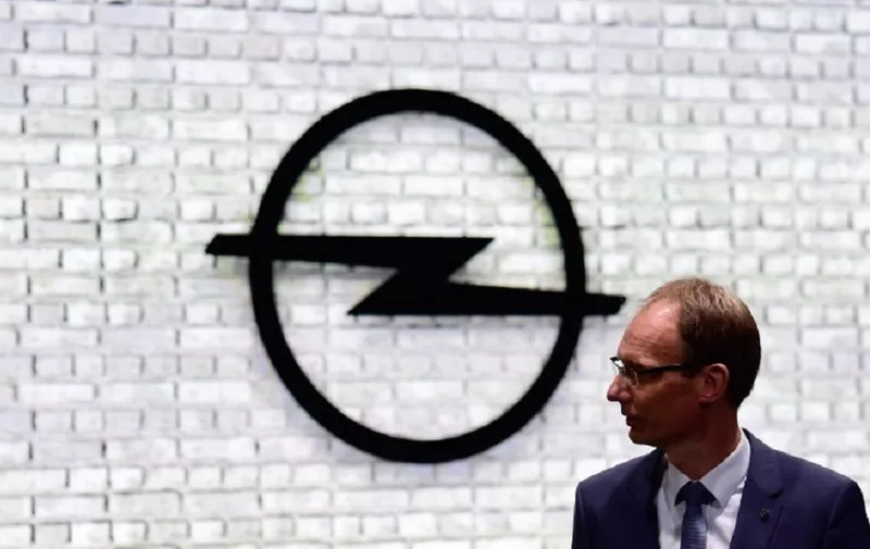 Michael Lohscheller, CEO of Opel, stands in front of his company's logo during the official opening of the Internationale Automobil Ausstellung (IAA) auto show on September 14, 2017 in Frankfurt am Main, western Germany. - According to organisers, around 1,000 exhibitors from 39 countries will showcase their products and services. This year's fair running from September 14 to 24, 2017 will focus on digitization, urban mobility and electric mobility. (Photo by Tobias SCHWARZ / AFP)