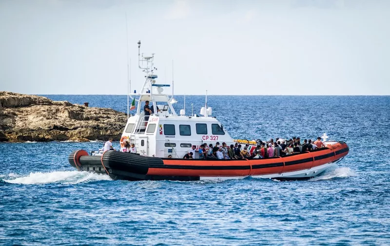 Migrants aboard a Guradia di Finanza and Navy military vessel are tranferred from the so-called migrant "Hotspot" operational processing facility on the southern Italian Island of Lampedusa, south of Sicily, to another center, on July 11, 2022. (Photo by Alessandro SERRANO / AFP)