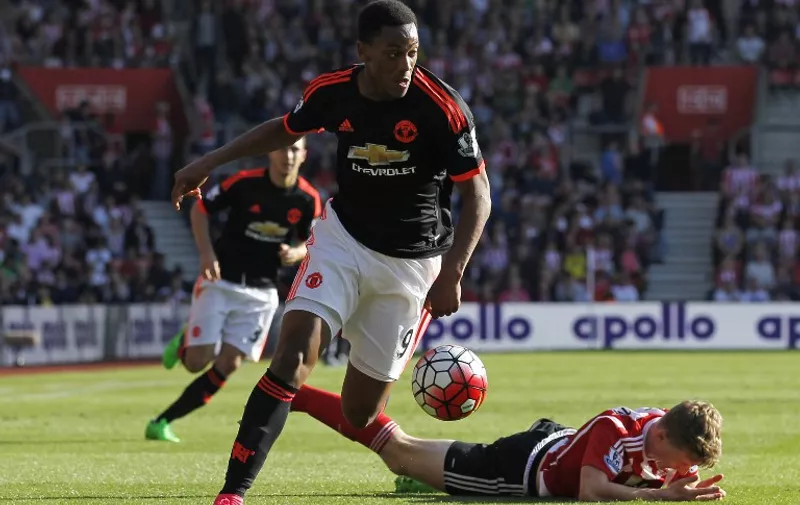 Manchester United's French striker Anthony Martial runs with the ball as Southampton's English defender Matt Targett (R) lies injured during the English Premier League football match between Southampton and Manchester United at St Mary's Stadium in Southampton, southern England on September 20, 2015. AFP PHOTO / IAN KINGTON

RESTRICTED TO EDITORIAL USE. No use with unauthorized audio, video, data, fixture lists, club/league logos or 'live' services. Online in-match use limited to 75 images, no video emulation. No use in betting, games or single club/league/player publications.