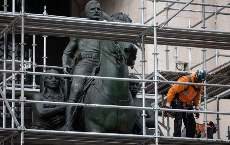 Construction workers erect scaffolding around the statue of US President Theodore Roosevelt at the American Museum of Natural History in New York City on December 2, 2021. - New York has begun the extended process of removing a statue of former US president Theodore Roosevelt, which has been long criticized as a racist and colonialist symbol and became a cultural flashpoint in recent years. The statue depicts Roosevel on horseback with Native American and African American figures standing at his side. (Photo by Yuki IWAMURA / AFP)