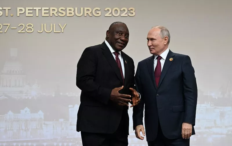 This pool image distributed by Sputnik agency shows Russian President Vladimir Putin greeting South Africa's President Cyril Ramaphosa during a welcoming ceremony at the second Russia-Africa summit in Saint Petersburg on July 27, 2023. (Photo by Pavel BEDNYAKOV / POOL / AFP)