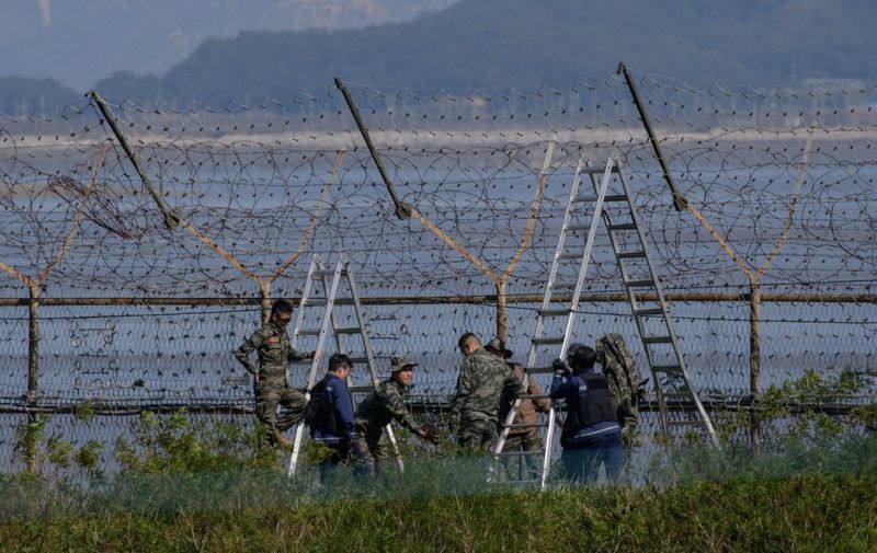 South Korean soldiers work on a section of a fence of the Demilitarized Zone (DMZ) separating North and South Korea, on the South Korean island of Gyodong on October 6, 2020. (Photo by Ed JONES / AFP)