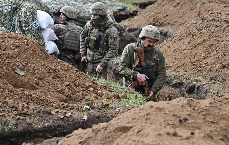 Ukrainian servicemen stand in a trench near their position near the town of Bakhmut, Donetsk region on April 8, 2023, amid the Russian invasion of Ukraine. Bakhmut has become the longest and bloodiest battle in Ukraine. Both sides have endured heavy losses in the eastern industrial city, home to around 70,000 people before the war. (Photo by Genya SAVILOV / AFP)