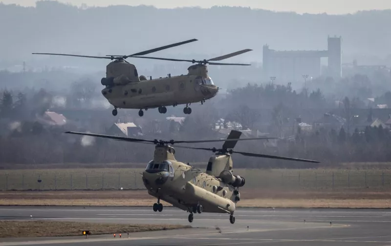 US Air Force CH-47 Chinook helicopters are seen landing at the airport in Jasionka near Rzeszow, south eastern Poland, February 16, 2022. - Dozens of US paratroopers landed at Rzeszow Airport in Poland -- part of a deployment of several thousand sent to bolster NATO's eastern flank in response to tensions with Russia. (Photo by Wojtek RADWANSKI / AFP)