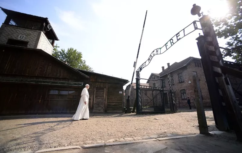 Pope Francis walks towards the main entrance with the lettering "Arbeit Macht Frei" (Work Sets You Free) at the former Nazi German Auschwitz-Birkenau death camp on July 29, 2016 in Oswiecim as part of his visit to the World Youth Days (WYD).
Pope Francis is in Poland for an international Catholic youth festival with a mission to encourage openness to migrants. / AFP PHOTO / FILIPPO MONTEFORTE