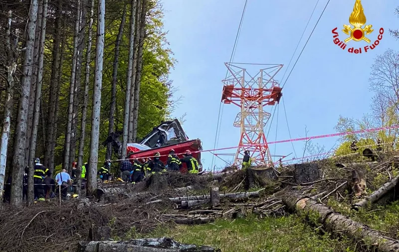 A photo taken and handout on May 23, 2021 by The Italian Firefighters "Vigili del Fuoco" shows rescuers working by a cable car that crashed to the ground in the resort town of Stresa on the shores of Lake Maggiore in the Piedmont region. - 13 people died and two children were seriously injured Sunday after a cable car crashed to the ground in northern Italy, emergency services said. (Photo by Handout / Vigili del Fuoco / AFP) / RESTRICTED TO EDITORIAL USE - MANDATORY CREDIT "AFP PHOTO / VIGILI DEL FUOCO / HANDOUT " - NO MARKETING - NO ADVERTISING CAMPAIGNS - DISTRIBUTED AS A SERVICE TO CLIENTS
