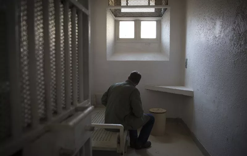 A journalist takes notes on September 10, 2014 in a cell at the Sante prison in Paris. The only jail in Paris, inaugurated in 1867, closed for renovations on July 21 and is to reopen in 2019 with its prisoners transferred to other facilities. The Sante is known  for its VIP section, where various well-known figures have done time. AFP PHOTO/JOEL SAGET / AFP PHOTO / JOEL SAGET