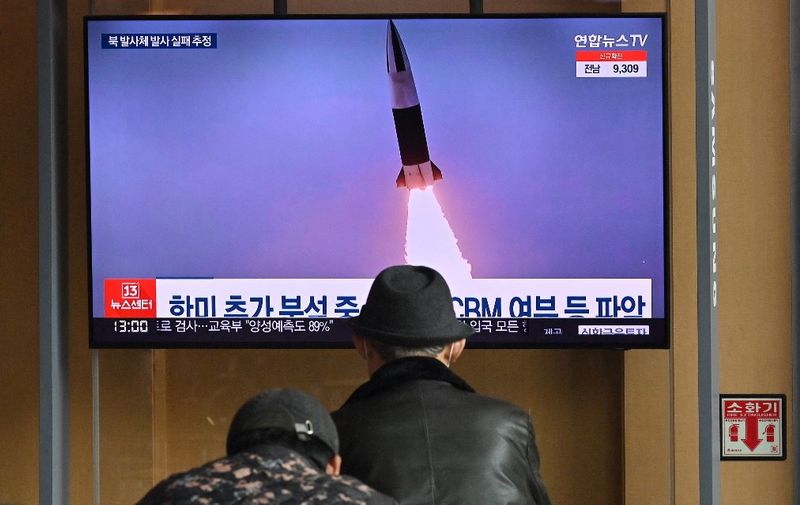 People watch a television screen showing a news broadcast with file footage of a North Korean missile test, at a railway station in Seoul on March 16, 2022, after North Korea fired an "unidentified projectile" but appeared to have immediately failed according to the South's military. (Photo by Jung Yeon-je / AFP)