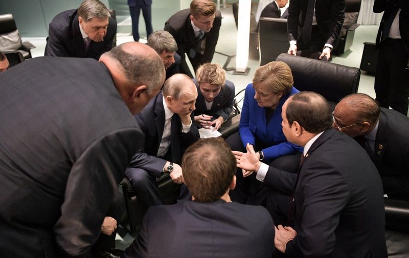 Egyptian President Abdul Fattah al-Sisi (R), Russian President Vladimir Putin (2ndL), German Chancellor Angela Merkel (2ndR) and French President Emmanuel Macron (front) talk on the sidelides of a Peace summit on Libya in Berlin on January 19, 2020. (Photo by Alexey NIKOLSKY / Sputnik / AFP)