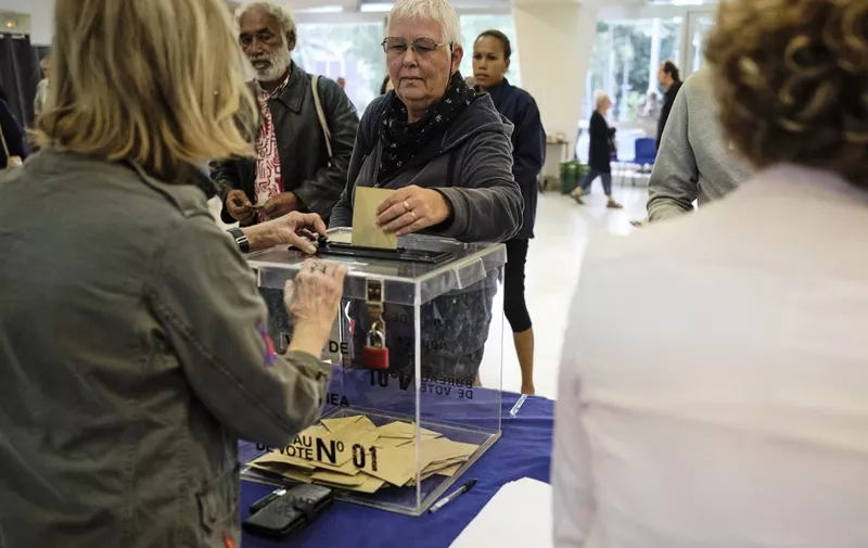People vote at the Hotel de Ville (city hall) polling station in Noumea, in the French Pacific territory of New Caledonia, during the second round of France's legislative elections on July 7, 2024. France votes in legislative elections on July 7 that will be decisive in determining its political future and could see the far right become the largest party in parliament for the first time. (Photo by Theo Rouby / AFP)