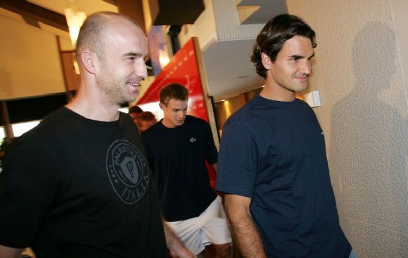 Croatia's Ivan Ljubicic (L) chats with world number one Roger Federer of Switzerland (R) as they leave with Andy Roddick of the US (C) from a press conference on the eve of the Kooyong Classic, in Melbourne 10 January 2006.  The top men's players use the round-robbin tournanment as a warm-up to the Australian Open with the Kooyong Classic producing the nine past winners of the Australian Open.  AFP PHOTO/William WEST / AFP / WILLIAM WEST