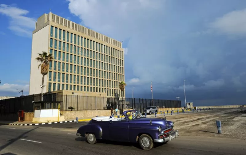 An old American car passes by the US Embassy in Havana on December 17, 2015. The United States announced Thursday the resumption of regular flights to and from Cuba, the latest step in a historic thaw in relations. "On December 16, the United States and Cuba reached a bilateral arrangement to establish scheduled air services between the two countries," the State Department said in a statement. / AFP PHOTO / YAMIL LAGE