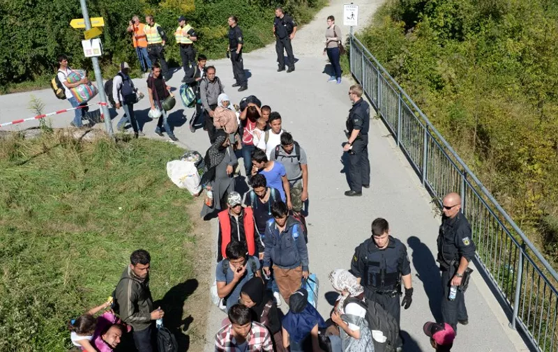 Refugees wait for police controls on a bridge crossing the border between Austria and Germany after leaving on foot Salzburg on their way to the Bavarian village of Freilassing, southern Germany, on September 16, 2015. Germany took the drastic measure of reinstating border controls on September 13, 2015 after being overwhelmed by a surge in asylum-seekers.
AFP PHOTO / CHRISTOF STACHE