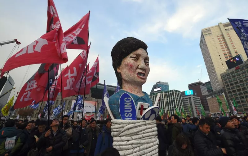 Protesters carry an effigy of South Korea's President Park Geun-Hye during an anti-government rally demanding the resignation of the president in central Seoul on November 30, 2016.
An impeachment vote against South Korea's scandal-hit president will be postponed by at least a week, lawmakers said on November 30, after Park Geun-Hye announced she was willing to stand down early. / AFP PHOTO / JUNG Yeon-Je