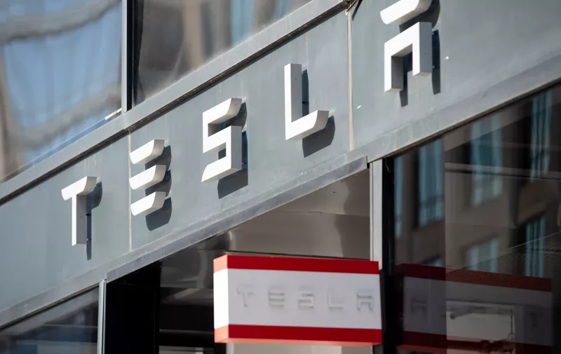 (FILES) In this file photo taken on August 8, 2018 the Tesla logo is seen outside of their showroom in Washington, DC. - Tesla's market value hit $100 billion for the first time on January 22, 2020, triggering a payout plan that could be worth billions for Elon Musk, founder and chief of the electric carmaker. Shares in Tesla rose some 4.8 percent in opening trade to extend the gains in the value of the fast-growing maker of electric vehicles. (Photo by SAUL LOEB / AFP)
