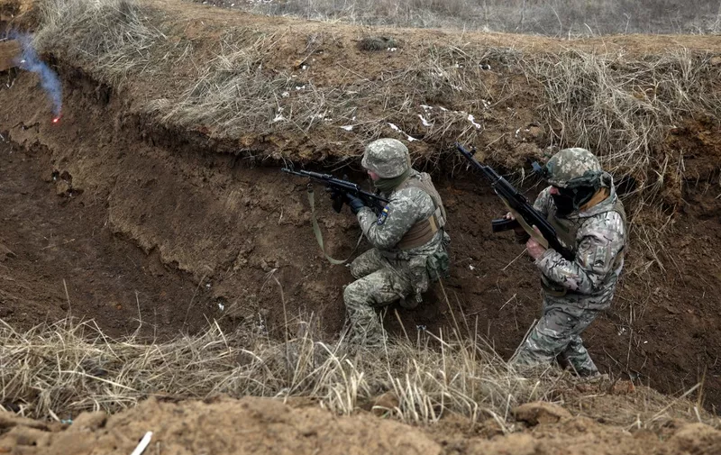 Ukrainian servicemen take position in a trench during a military training exercise near the front line in the Donetsk region, on February 23, 2024, amid the Russian invasion of Ukraine. (Photo by Anatolii STEPANOV / AFP)