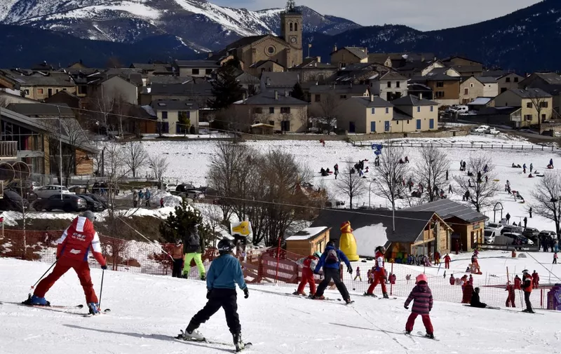Skiers ride slopes at Angles ski resort, southern France, on February 4, 2023. - A post office, four doctors, around fifty shops and craftsmen, 1,200 jobs in winter: Les Angles, in the Pyrenees-Orientales, is teeming with activity thanks to its ski resort, while mountain villages are struggling to maintain their economy and public services. (Photo by RAYMOND ROIG / AFP)