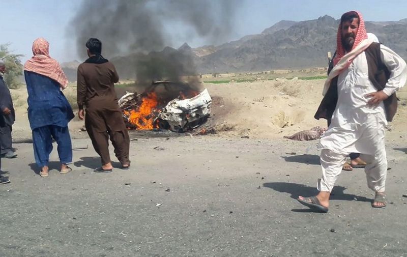 This photograph taken on May 21, 2016 shows Pakistani local residents gathering around a destroyed vehicle hit by a drone strike in which Afghan Taliban Chief Mullah Akhtar Mansour was believed to be travelling in the remote town of Ahmad Wal in Balochistan, around 160 kilometres west of Quetta.
Afghan authorities scrambled May 22 to confirm the fate of Taliban leader Mullah Akhtar Mansour after US officials said he was likely killed in drone strikes -- a potential blow to the resurgent militant movement.
 / AFP PHOTO / -