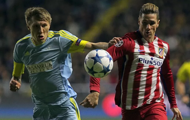 Astana's Kazakh defender Evgeni Postnikov (L) vies for the ball with Atletico Madrid's forward Fernando Torres during the UEFA Champions League group C football match between FC Astana and Club Atletico de Madrid at the Astana Arena stadium in Astana on November 3, 2015. 