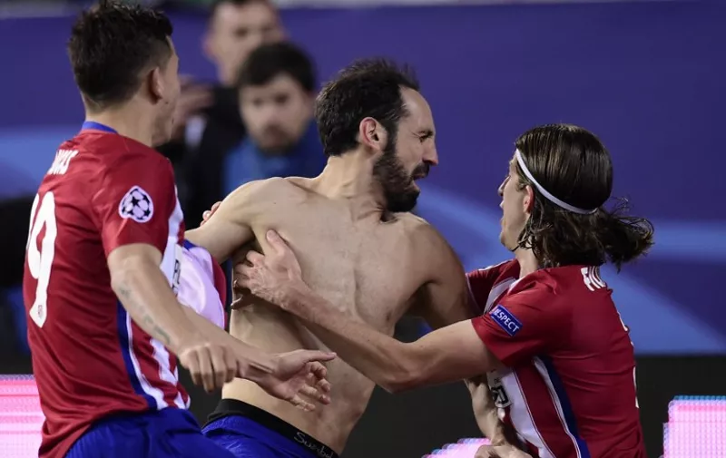 Atletico Madrid's defender Juanfran celebrates with teammates after kicking the winning penalty during the UEFA Champions League last sixteen second leg football match Club Atletico de Madrid vs PSV Eindhoven at the Vicente Calderon stadium in Madrid on March 15, 2016. / AFP / JAVIER SORIANO