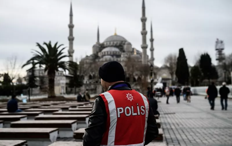 A Turkish police officers standS guard on January 15, 2016 near a makeshift memorial in tribute to the victims of January 12 deadly attack at the Istanbul's tourist hub of Sultanahmet in Istanbul.
Turkish ground forces pounded Islamic State jihadists in Iraq and Syria after a suicide attack blamed on the extremists killed 10 German tourists, Prime Minister Ahmet Davutoglu said on Thursday, in a significant escalation of Ankara's fight against the group. / AFP / OZAN KOSE