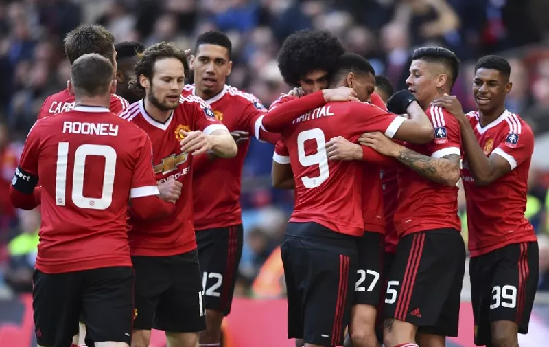 Manchester United players celebrate Manchester United's Belgian midfielder Marouane Fellaini after he scored the opening goal during the English FA Cup semi-final football match between Everton and Manchester United at Wembley Stadium in London on April 23, 2016. / AFP PHOTO / BEN STANSALL / NOT FOR MARKETING OR ADVERTISING USE / RESTRICTED TO EDITORIAL USE