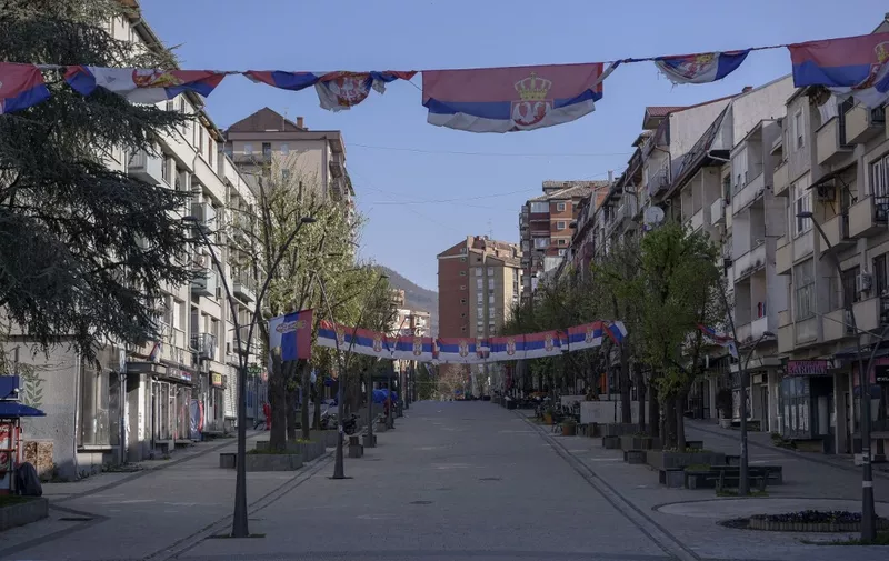 Serbian flags flutter in an empty street in the north of Mitrovica, predominantly populated by the ethnic Serb minority amid the municipal elections in the north of Kosovo, on April 23, 2023. - Serbs in northern Kosovo are boycotting the extraordinary local elections as they refuse political loyalty to Pristina. Not allowing the use of school premises for voting, election authorities were forced to set up 13 containers across the North. (Photo by Armend NIMANI / AFP)