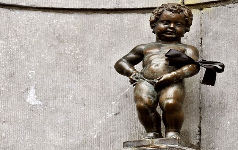 The Belgian statue Manneken pis wears a black arm band on March 16, 2012. Belgium observes a national day of mourning for the victims of the March 13 bus crash near the town of Sierre in southern Switzerland. Twenty-eight people died in the crash, including 22 children from two schools of Lommel and Heverlee, who were returning to Belgium from a skiing holiday. The first survivors of the accident returned to Belgium on March 16 .  AFP PHOTO  / GEORGES GOBET / AFP / GEORGES GOBET