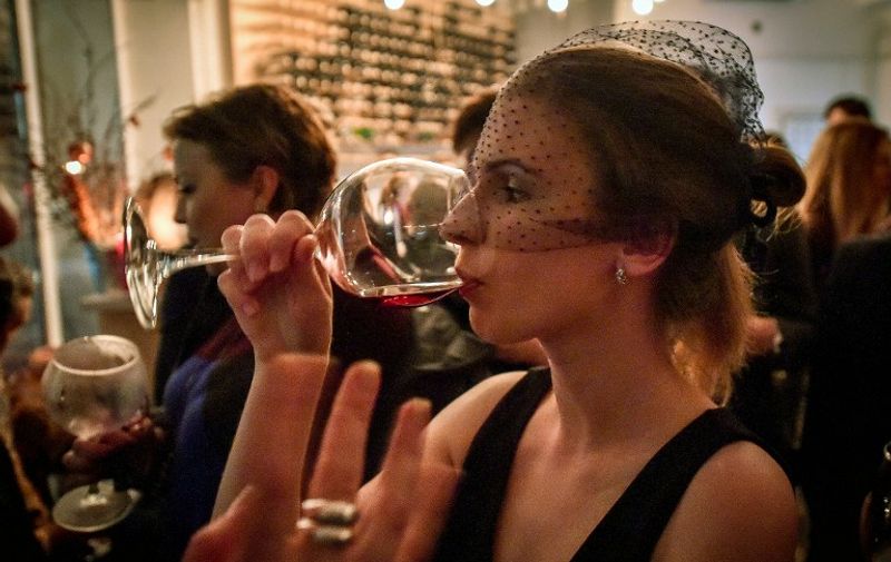 A Belarus woman drinks a glass of the 2014 Beaujolais Nouveau wine during an event at the U-bar in Minsk on November 20, 2014.                AFP PHOTO / MAXIM MALINOVSKY / AFP / MAXIM MALINOVSKY