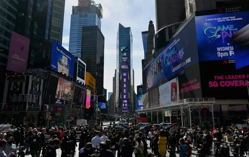 People gather at Time Square after 'We Will Be Back', a live pop-up event and commemoration of Broadway's 'lost year' on March 12, 2021 in New York City. - The theater community reunited exactly one year since Broadway shutdown due to the covid-19 pandemic. (Photo by Angela Weiss / AFP)