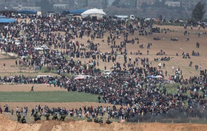 A picture taken from the Israeli side of the Israeli Gaza border shows Palestinians marching to the border area in a protest dubbed the "Great March of Return" to mark the 42 Anniversary of the Palestinian Land Day, 30 March 2018. The march is to highlight the hundreds of thousands of Palestinian refugees who were expelled or fled their homes during the 1948 war that marked Israel's creation. Photo: Oren Ziv/dpa