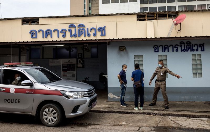 Police officers talk outside the Surat Thani Hospital morgue and forensics lab in southern Thailand's Surat Thani province on March 6, 2022, as Thai authorities prepare to conduct an autopsy on the body of Australian cricket player Shane Warne, who died of a suspected heart attack on March 4 after being found unresponsive in a luxury resort villa on Koh Samui. (Photo by Jack TAYLOR / AFP)