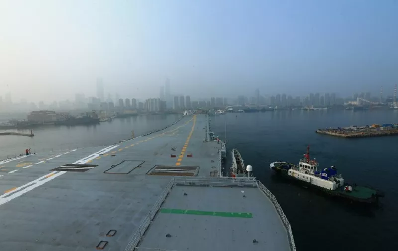 China's first domestically manufactured aircraft carrier, known only as "Type 001A", (L) leaves port in the northeast city of Dalian early on May 13, 2018. 
China's first domestically manufactured aircraft carrier started sea trials on May 13, 2018, state media said, as the country prepares to add a second such warship to its naval fleet. / AFP PHOTO / - / China OUT