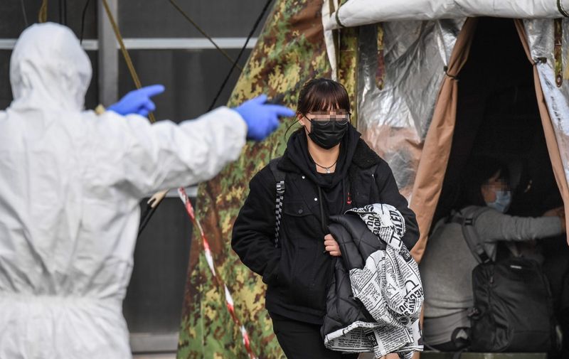 An Italian citizen (C) repatriated from the coronavirus hot-zone of Wuhan is directed to a health control zone after landing at the Mario De Bernardi military airport in Pratica di Mare, south of Rome, on February 3, 2020 prior to be placed in quarantine at the nearby Cecchignola center. (Photo by - / ANSA / AFP) / - Italy OUT / ADDING RESTRICTIONS- The metadata of this photo has been modified in AFP systems in the following manner: [ITALY OUT and XGTY] instead of [-]. Please immediately remove the erroneous mention[s] from all your online services and delete it (them) from your servers. If you have been authorized by AFP to distribute it (them) to third parties, please ensure that the same actions are carried out by them. Failure to promptly comply with these instructions will entail liability on your part for any continued or post notification usage. Therefore we thank you very much for all your attention and prompt action. We are sorry for the inconvenience this notification may cause and remain at your disposal for any further information you may require. / XGTY - Italy OUT