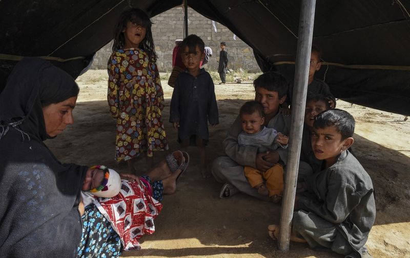 Afghan refugees sit inside a makeshift tent shelter on the outskirts of Quetta on September 6, 2021. (Photo by Banaras KHAN / AFP)