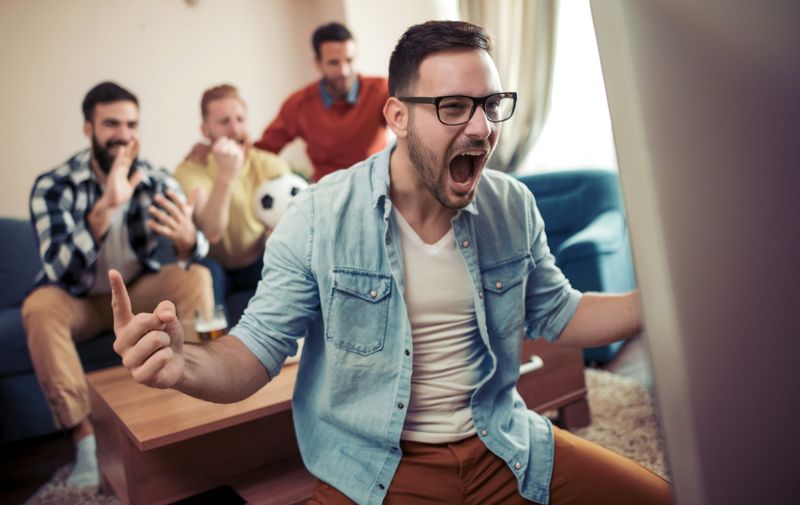 Group of friends watching soccer game on television and celebrating goal.; Shutterstock ID 1172779486; Purchase Order: -